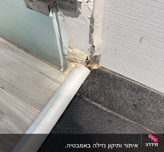 נזילה בקיר ליד צינור מתכת ופינה רטובה